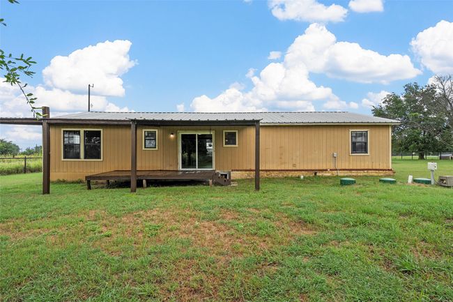 Back of house featuring a yard and a metal roof | Image 21