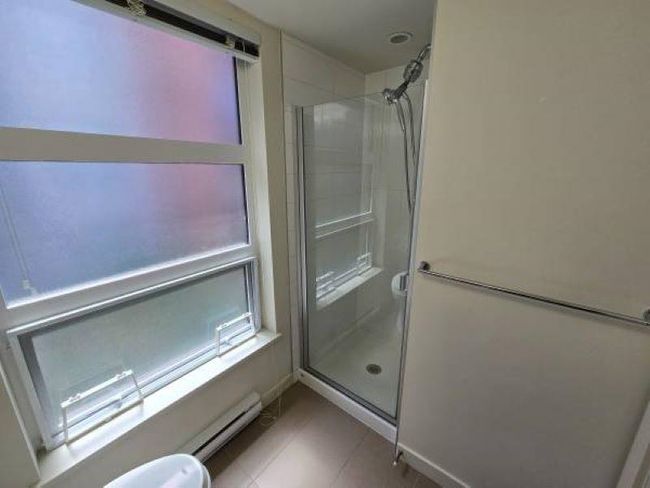 Bathroom featuring a stall shower, toilet, and baseboard heating | Image 20