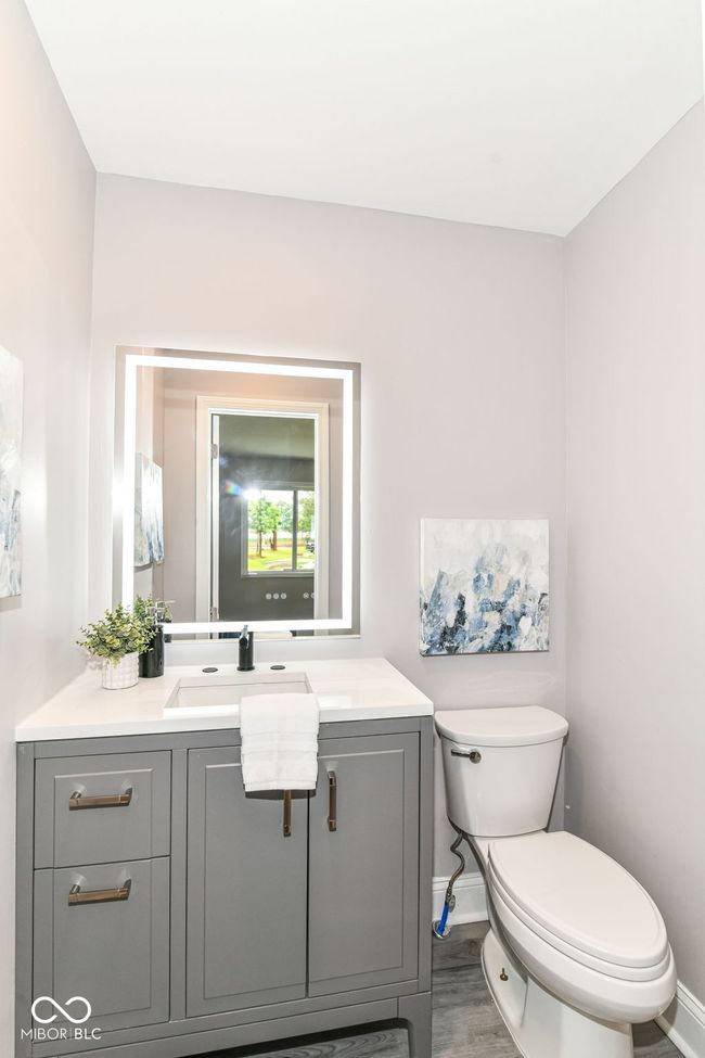 bathroom featuring toilet, vanity, baseboards, and wood finished floors | Image 12