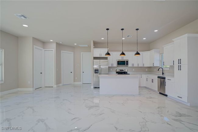 Kitchen featuring light countertops, recessed lighting, stainless steel appliances, a sink, and visible vents | Image 5