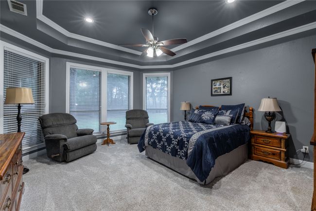 Bedroom with carpet, a tray ceiling, ornamental molding, recessed lighting, and ceiling fan | Image 22