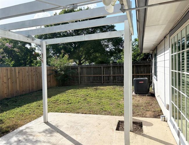 Step outside to a lovely patio area enhanced with a wooden frame, ready for your choice of climbing plants or artificial covering to create your own private retreat. | Image 20