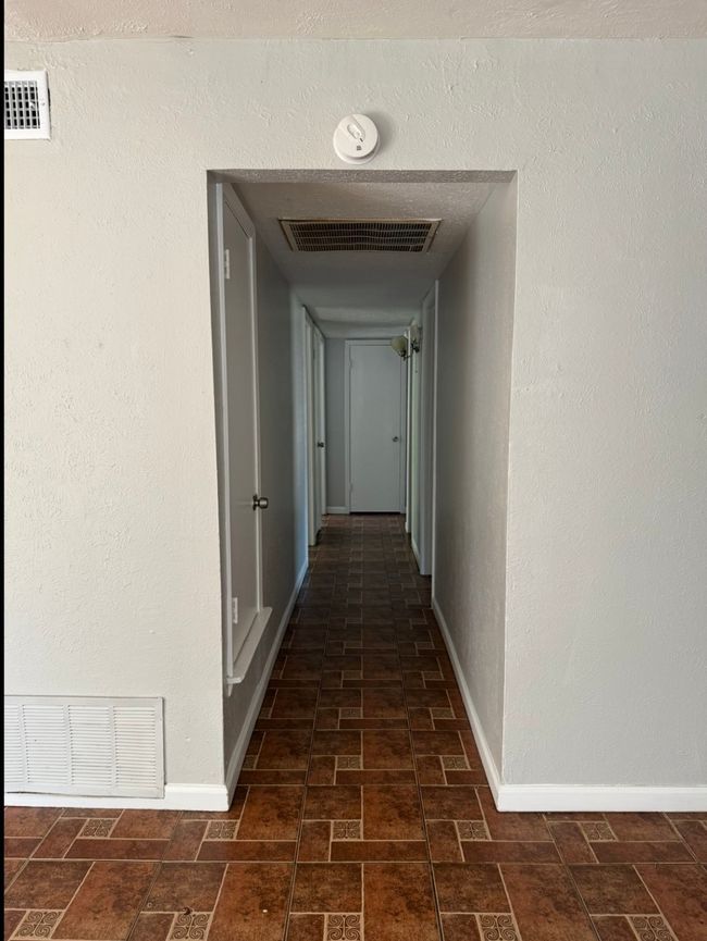 Hallway featuring baseboards and brick patterned flooring | Image 12