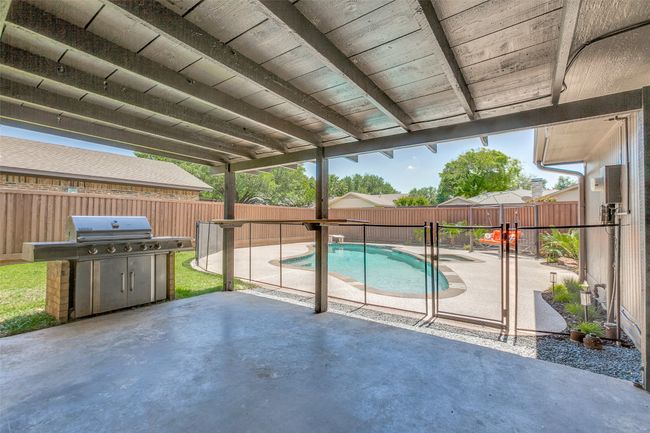 View of swimming pool featuring a patio area, a fenced backyard, and area for grilling | Image 31