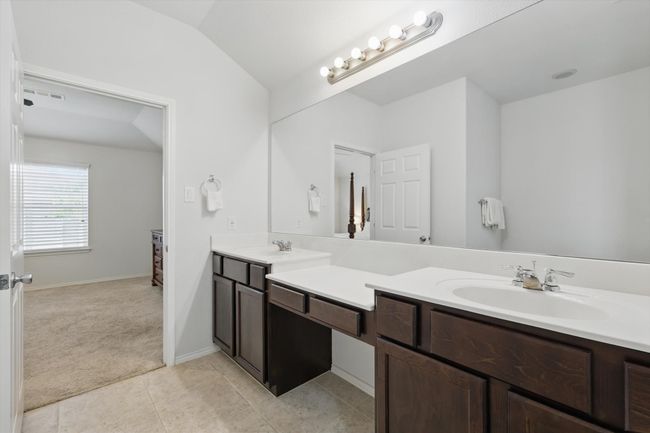 Bathroom with vaulted ceiling, double vanity, visible vents, and a sink | Image 32