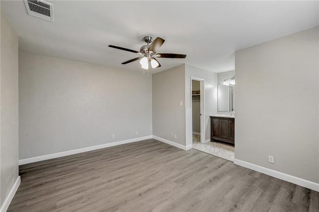 Empty room with light wood finished floors, baseboards, and a ceiling fan | Image 21