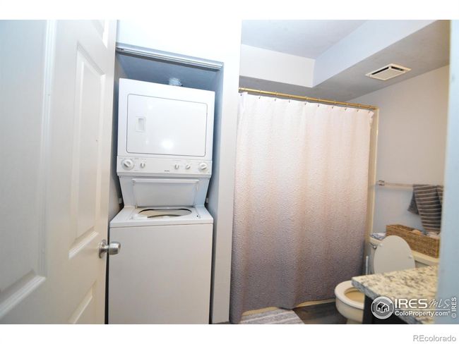 bathroom with stack washer & dryer | Image 11