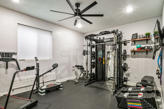 Exercise room featuring a ceiling fan and a textured ceiling | Image 84