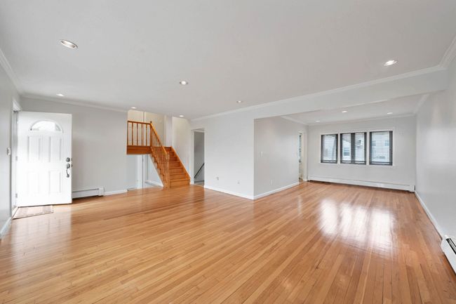 Unfurnished living room with a baseboard heating unit and light hardwood / wood-style flooring | Image 6