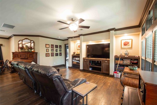 Living room featuring dark wood finished floors, ceiling fan, ornamental molding, and baseboards | Image 8