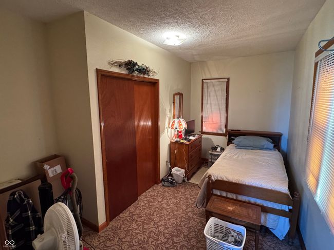 carpeted bedroom with a closet and a textured ceiling | Image 24