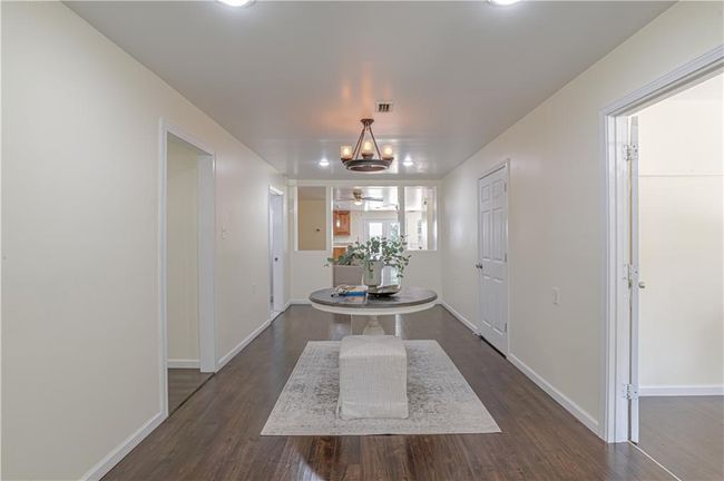 Corridor featuring dark hardwood / wood-style floors and an inviting chandelier | Image 13