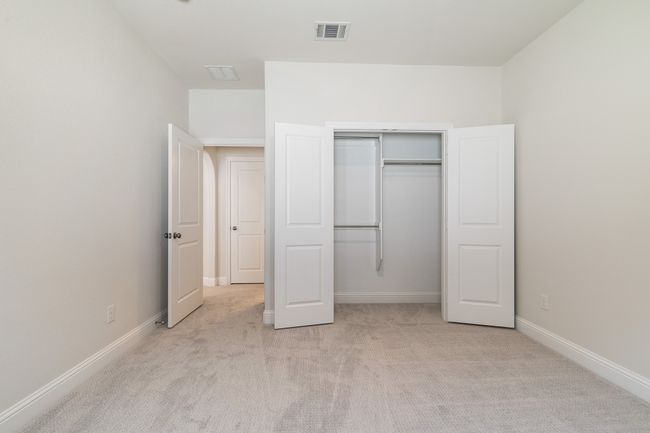 Unfurnished bedroom featuring baseboards, visible vents, light colored carpet, and a closet | Image 27