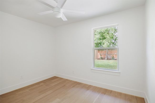 Empty room with light wood-style flooring and a ceiling fan | Image 25