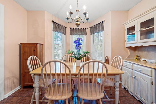 Dining room featuring a chandelier, healthy amount of natural light, baseboards, and dark tile patterned floors | Image 18