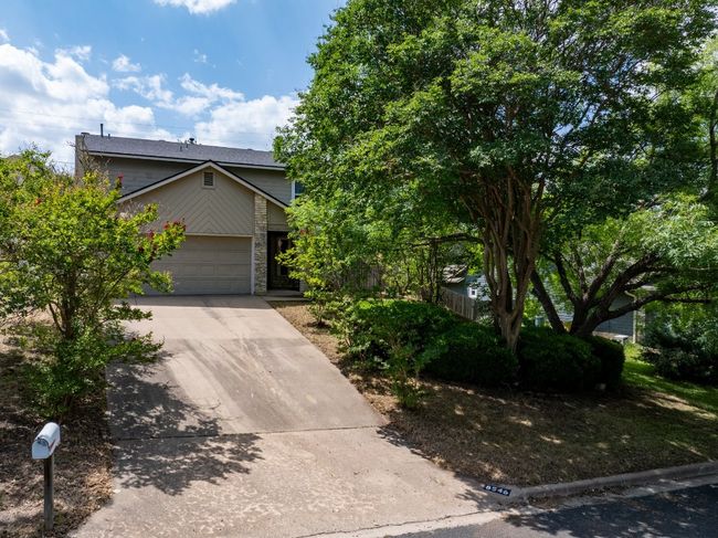 Obstructed view of property featuring concrete driveway, an attached garage, and stone siding | Image 20