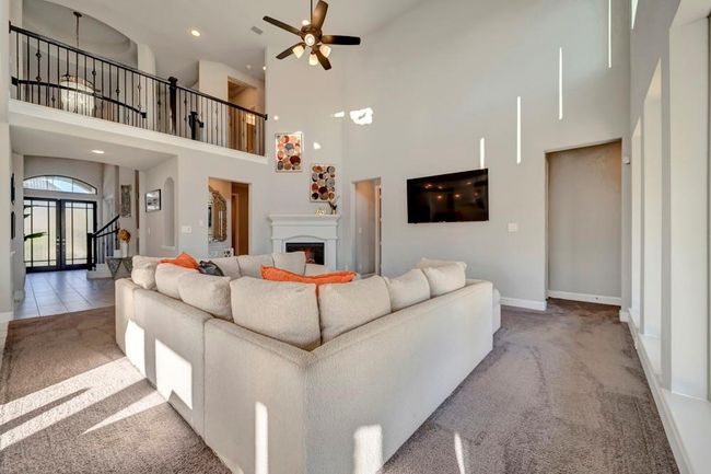 Family room looking back towards the front door. The upstairs is visible with the beautiful railing. Natural light dances on the walls! | Image 9
