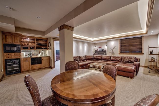 Head to the lower level to check out another warm and cozy gathering space. Built-in wet bar and space for games! | Image 32