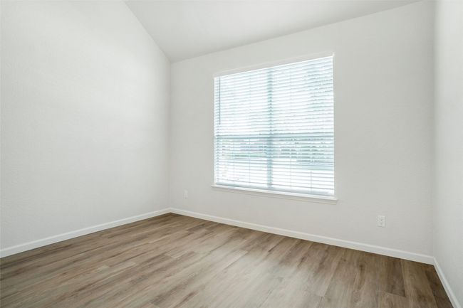 Spare room featuring light wood-style flooring, lofted ceiling, and baseboards | Image 20