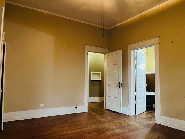 Unfurnished room featuring ornamental molding, dark wood-type flooring, baseboards, and a desk | Image 10