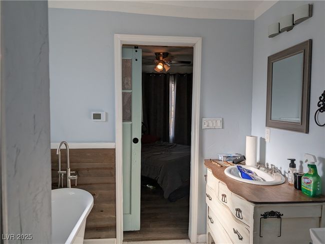 Bathroom featuring a soaking tub, wainscoting, a ceiling fan, and vanity | Image 15