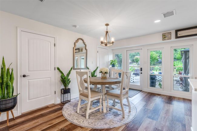 The breakfast area is filled with natural light from multiple windows, features durable vinyl flooring, and offers easy access to the backyard for seamless indoor-outdoor living. | Image 5