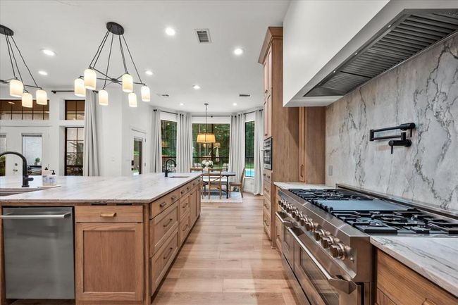 Sleek and stylish, the full-height marble backsplash, pot filler, and under-cabinet lighting bring function and flair to your everyday meals. | Image 13