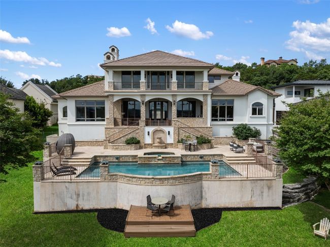 Back of house featuring a balcony, stucco siding, a patio, and stairs | Image 28