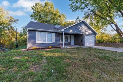 Ranch-style home with a front yard and a garage | Image 1