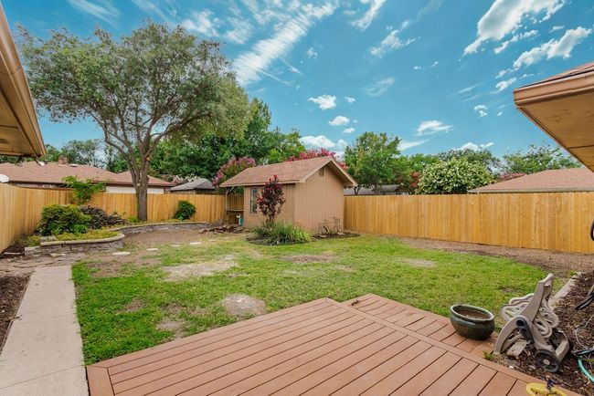 Fenced backyard with a deck and a shed | Image 25
