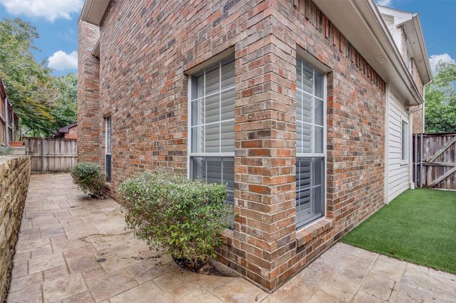 View of property exterior featuring brick siding and a patio area | Image 24
