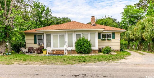 Bungalow-style home with entry steps, a chimney, and roof with shingles | Image 38