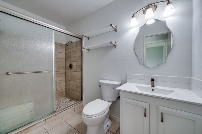 Full bathroom with vanity, a stall shower, tile patterned flooring, and decorative backsplash | Image 16