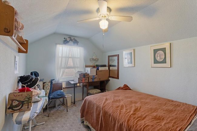 Bedroom featuring ceiling fan, lofted ceiling, light colored carpet, and a textured ceiling | Image 24