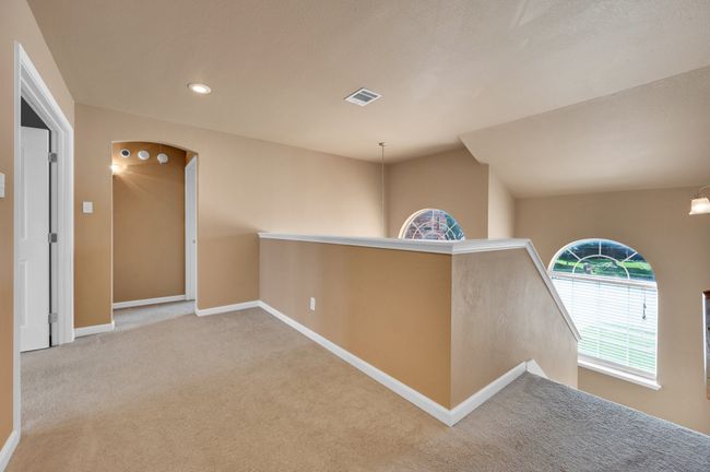 Corridor featuring an upstairs landing, carpet flooring, recessed lighting, and arched walkways | Image 31