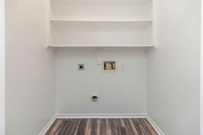 Laundry area with electric dryer hookup, washer hookup, dark wood finished floors, and baseboards | Image 25