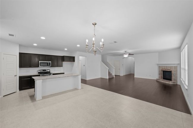 Kitchen with stainless steel appliances, recessed lighting, a chandelier, a brick fireplace, and open floor plan | Image 18