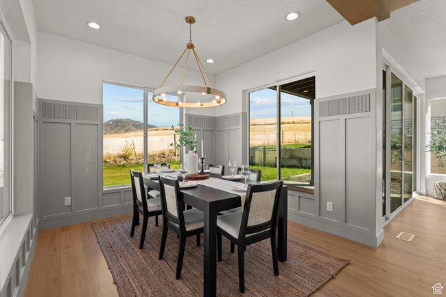 Dining room with a decorative wall, healthy amount of natural light, light wood-style floors, and recessed lighting | Image 26