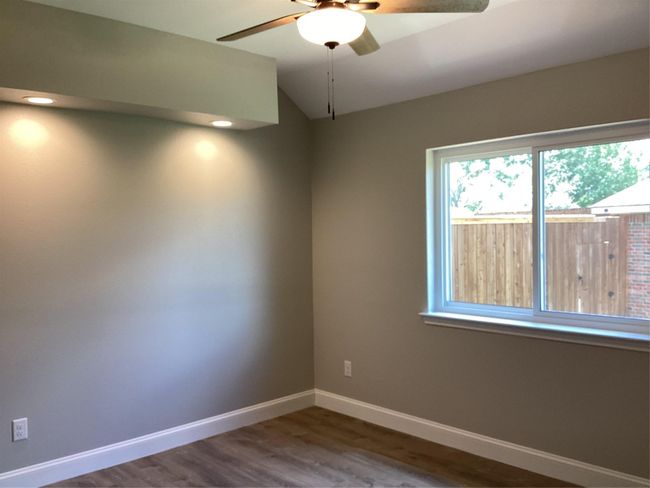 Spare room featuring ceiling fan, wood finished floors, and lofted ceiling | Image 25