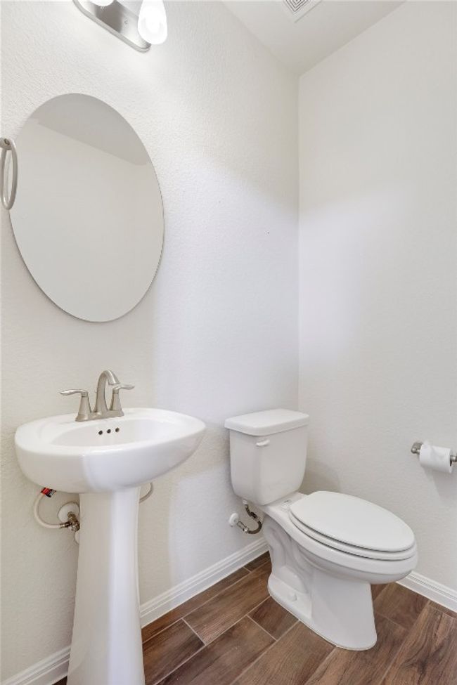 Bathroom with wood finished floors, toilet, baseboards, and a sink | Image 13