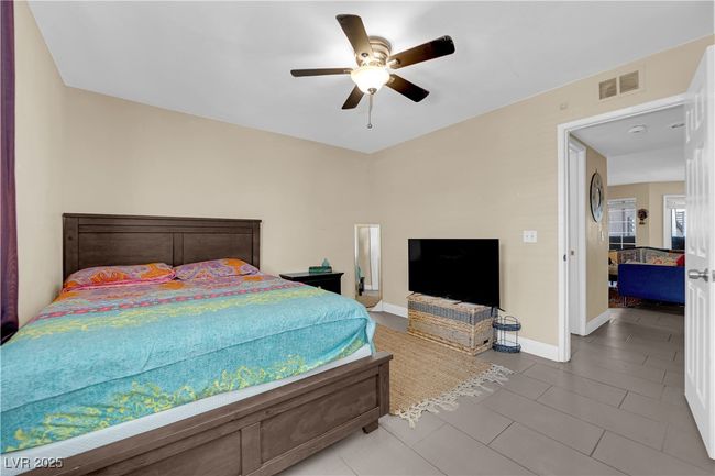 Tiled bedroom with baseboards, visible vents, and ceiling fan | Image 10