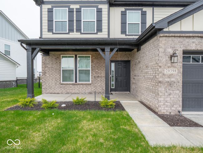 doorway to property featuring brick siding, fence, and a lawn | Image 6