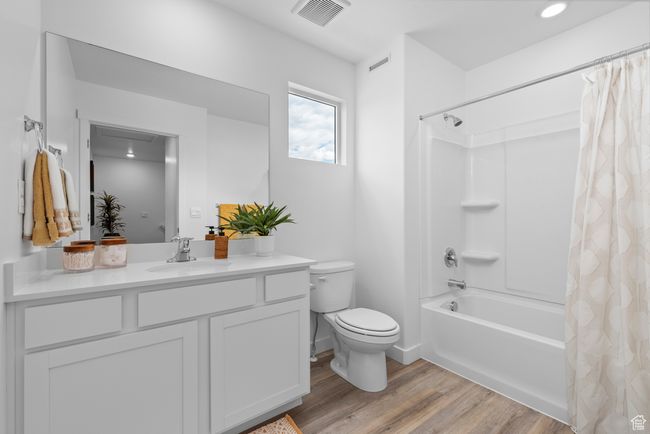 Full bathroom with wood finished floors, vanity, and shower / bath combination with curtain | Image 12