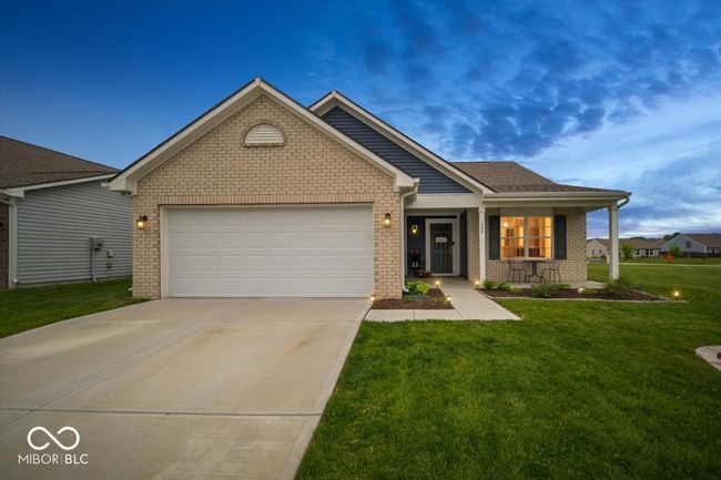 ranch-style home with brick siding, a garage, a front yard, driveway, and a porch | Image 4