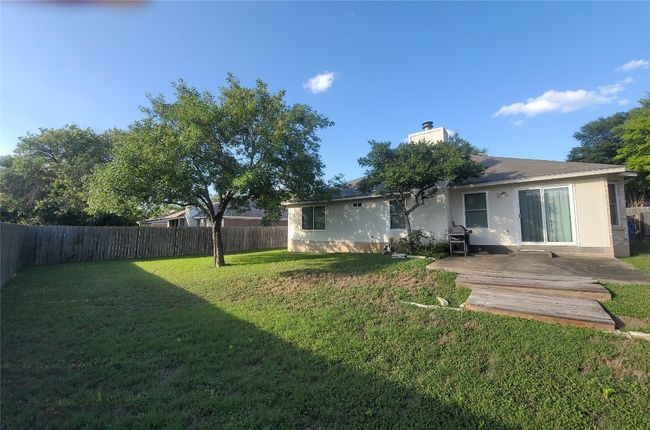 Fenced backyard with a patio area | Image 10