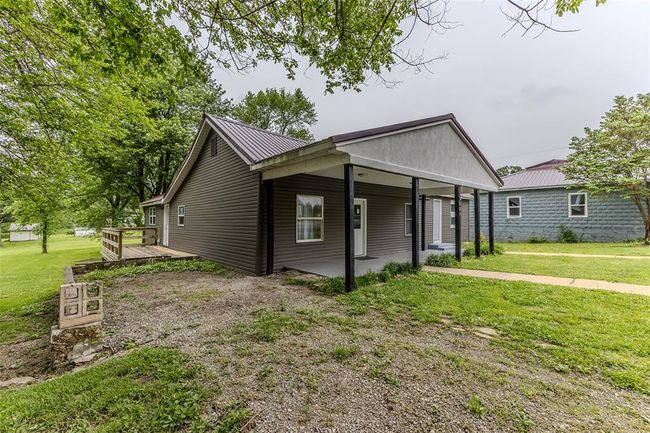 View of front of house with a front lawn, metal roof, and a wooden deck | Image 39