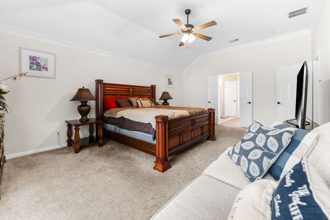 Bedroom featuring crown molding, light colored carpet, lofted ceiling, baseboards, and a ceiling fan | Image 19