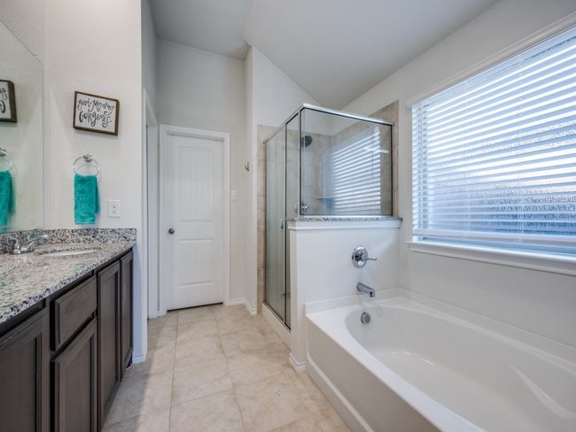 Bathroom featuring double vanity, a garden tub, a shower stall, and tile patterned flooring | Image 19