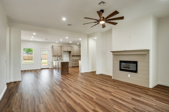 Unfurnished living room with baseboards, visible vents, and dark wood-type flooring | Image 4