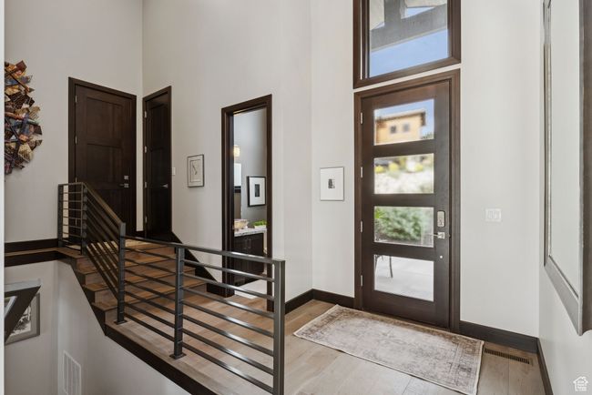 Entrance foyer with wood finished floors and a towering ceiling | Image 11